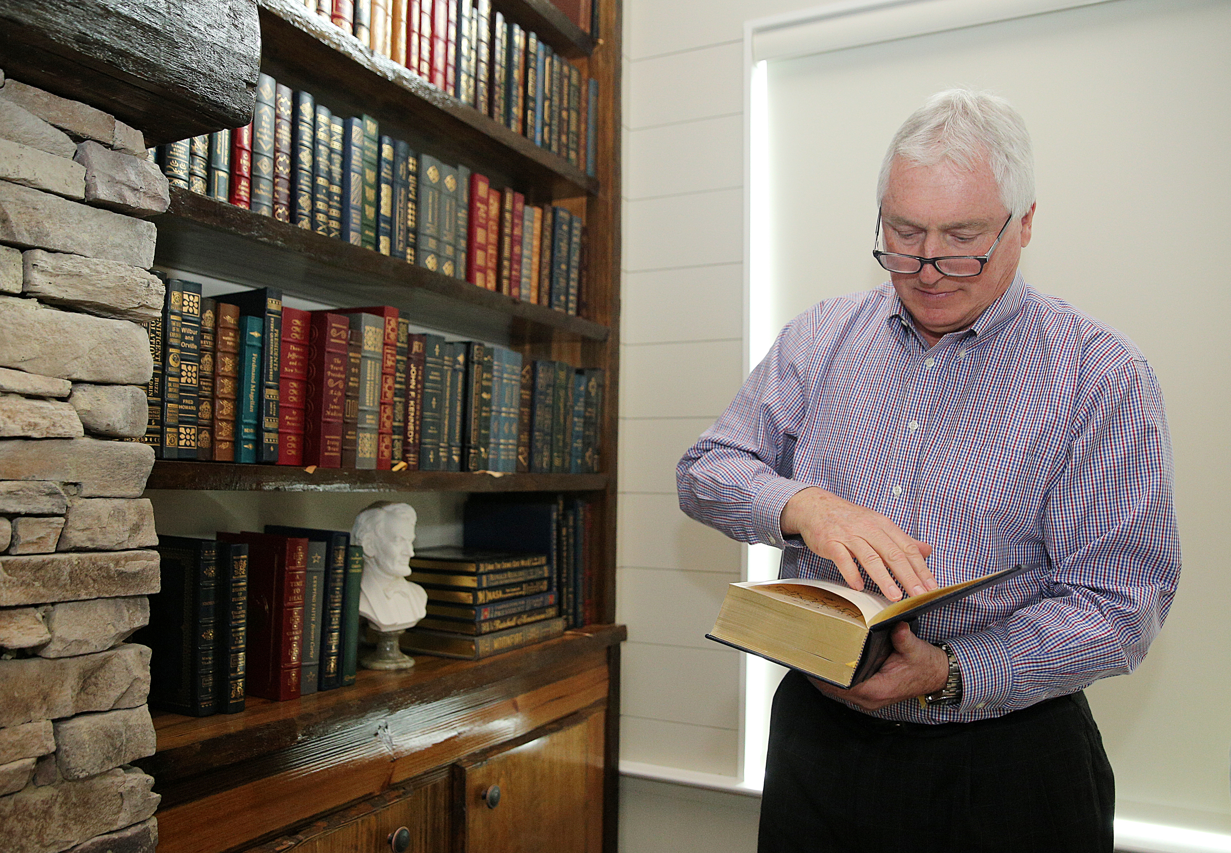 George Nelson flips through a signed copy of The Memoirs of Richard Nixon at Nelson's home Wednesday, Feb. 7, 2018 in Chattanooga, Tenn.