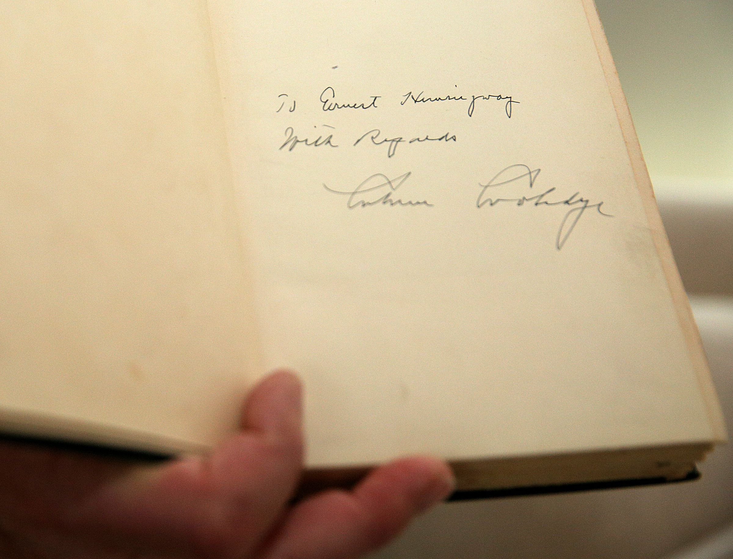 George Nelson holds his copy of Calvin Coolidge's autobiography at his home Wednesday, Feb. 7, 2018 in Chattanooga, Tenn. The book was addressed to Ernest Hemingway and signed by Coolidge.