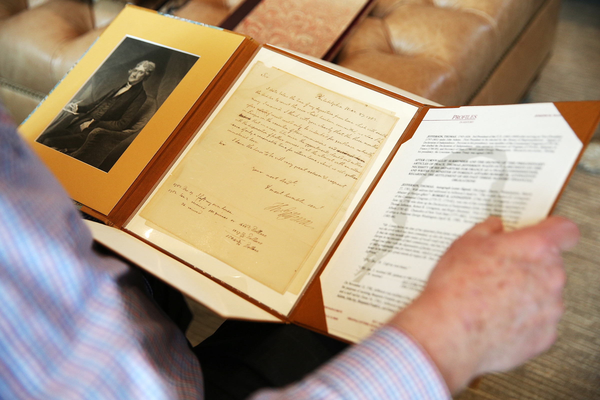 George Nelson holds a document signed by Thomas Jefferson at his home Wednesday, Feb. 7, 2018 in Chattanooga, Tenn. Nelson has a collection of documents and books signed by presidents and other well-known historical figures.