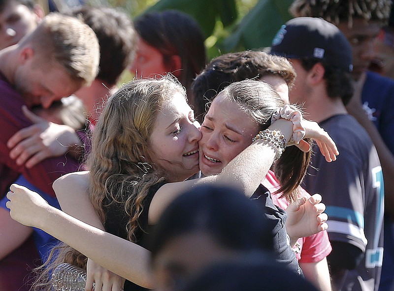 Students grieve at Pine Trails Park for the victims of the Wednesday shooting at Marjory Stoneman Douglas High School, in Parkland, Fla., Thursday, Feb. 15, 2018. Nikolas Cruz, a former student, was charged with 17 counts of premeditated murder on Thursday. (AP Photo/Brynn Anderson)