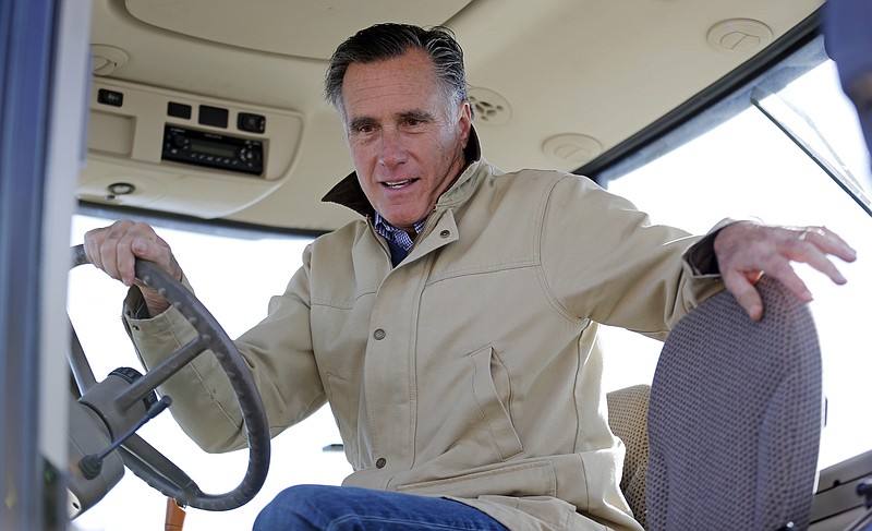 Former Republican presidential candidate Mitt Romney holds the wheel of a tractor during a tour of Gibson's Green Acres Dairy Friday, Feb. 16, 2018, in Ogden, Utah. 