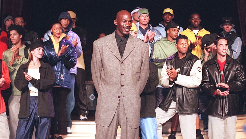 
              FILE - In this March 2,1999, file photo, Michael Jordan stands with a group of models at the Bellagio Hotel in Las Vegas where he previewed the Fall/Holiday 1999 Jordan collection, a sub-brand of Nike. By the 1980s, America finally publicly embraced the black athlete, looking past skin color to see athleticism and skill, rewarding stars with multimillion-dollar athletic contracts, movie deals, lucrative shoe endorsements and mansions in all-white enclaves. Who didn’t want to be like Mike? (Jim Laurie/Las Vegas Review-Journal via AP, File)
            