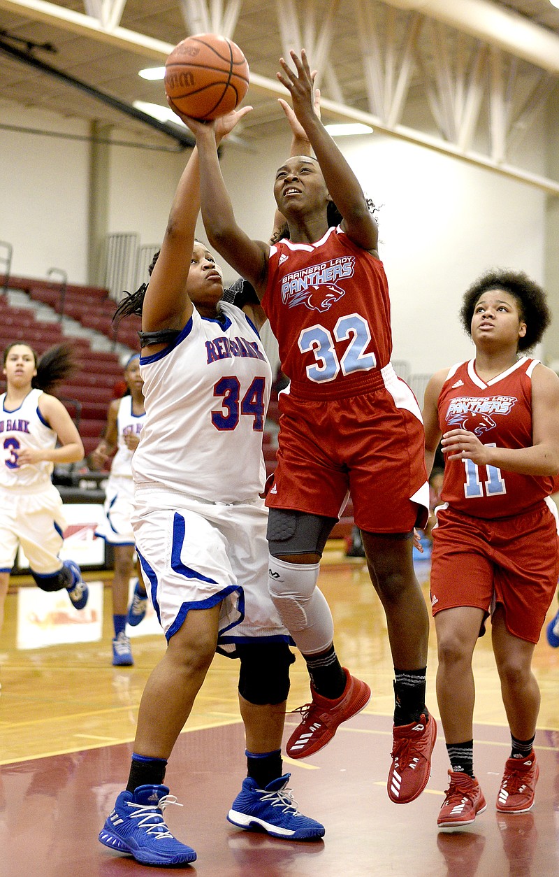 Brainerd's Kimia Carter (32) drives to the hoop inside Red Bank's Bailey Lee during a TSSAA District 6-AA tournament game at Howard in February 2018.