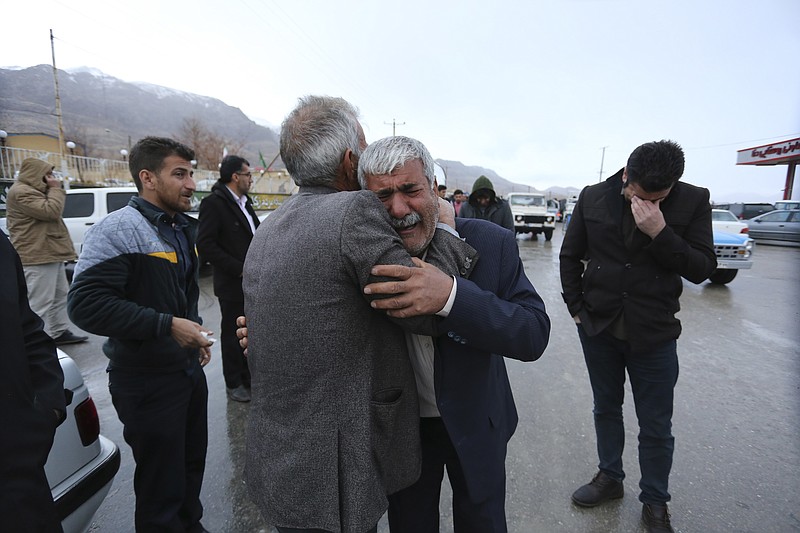 In this photo provided by Tasnim News Agency, family members of a plane crash victims weep in the village of Bideh, at the area that the plane crashed, southern Iran, Sunday, Feb. 18, 2018. An Iranian commercial plane crashed Sunday in a foggy, mountainous region of southern Iran, and officials said they feared all people aboard were killed. (Ali Khodaei/Tasnim News Agency via AP)