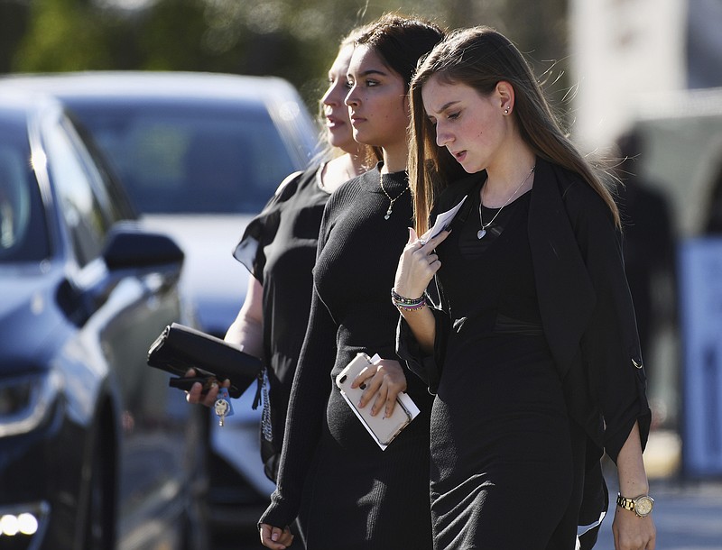 Mourners leave the funeral service at Temple Beth El in Boca Raton, Fla., for Scott Beigel, a teacher at Marjory Stoneman Douglas High School who was killed in Wednesday's mass shooting, on Sunday, Feb. 18, 2018. (Jim Rassol/South Florida Sun-Sentinel via AP)