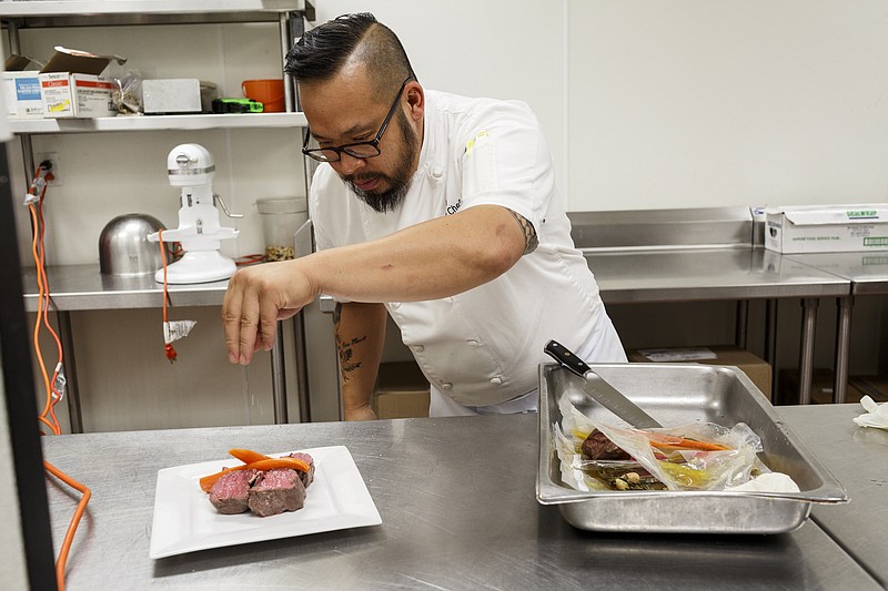 Chef Dao Le plates a filet cooked by a sous vide machine at Eleven restaurant in the DoubleTree hotel on Wednesday, May 17, 2017, in Chattanooga, Tenn. A sous vide machine heats water to cook vacuum-sealed food to precise temperatures.