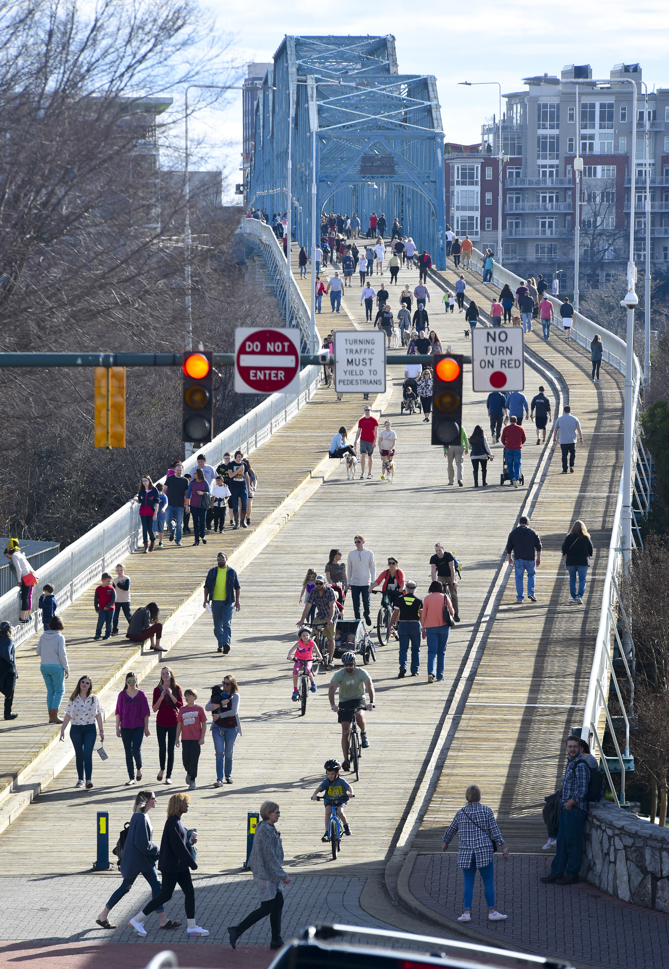 The Walnut Street Bridge vibrates with heavy pedestrian traffic Sunday afternoon as temperatures soar into the mid-60s, with ample sunshine.