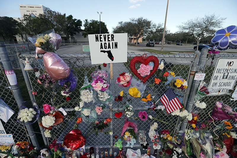 A makeshift memorial is seen outside the Marjory Stoneman Douglas High School, where 17 students and faculty were killed in a mass shooting on Wednesday, in Parkland, Fla., Monday, Feb. 19, 2018. Nikolas Cruz, a former student, was charged with 17 counts of premeditated murder on Thursday. (AP Photo/Gerald Herbert)
