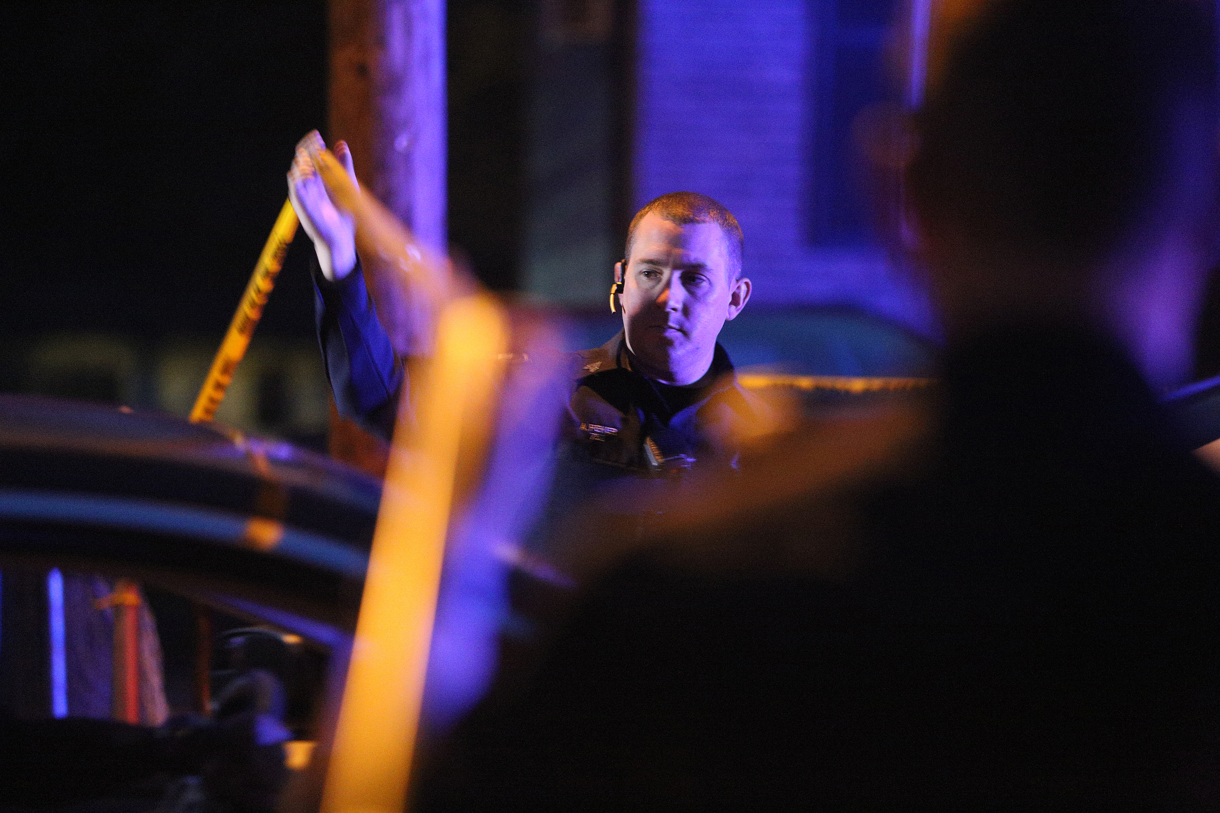 A Chattanooga police officer raises crime scene tape for a car exiting the scene of a shooting Tuesday, Feb. 20, 2018 in the 1400 block of Carousel Road in Chattanooga, Tenn. One person is deceased following the incident and another is in critical condition.
