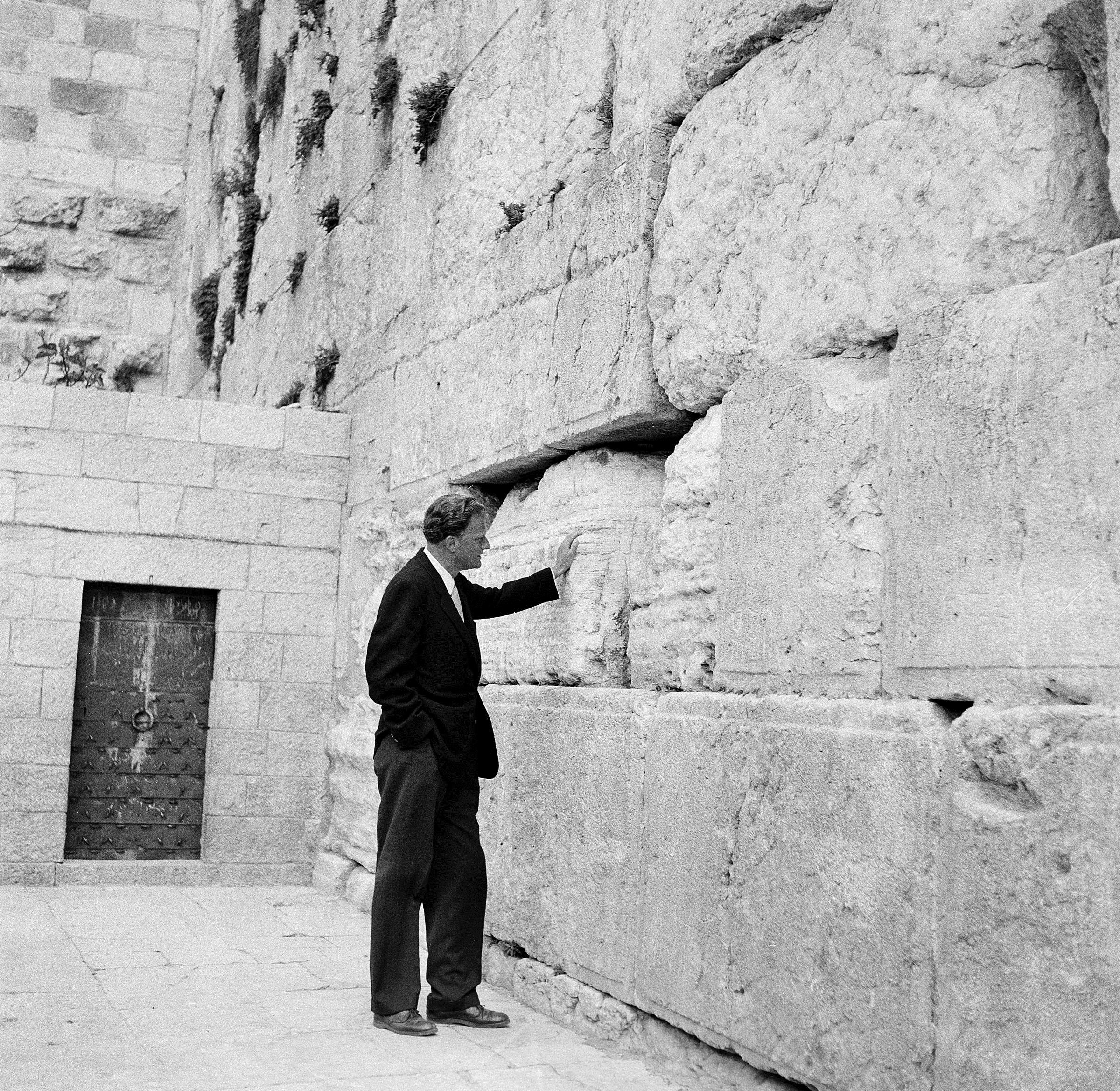 Evangelist Billy Graham stands by the Wailing Wall in Jerusalem, March 17, 1960. Graham has been on an 18,000-mile preaching tour of Africa and the Middle East. (AP Photo/Leila Wynn)