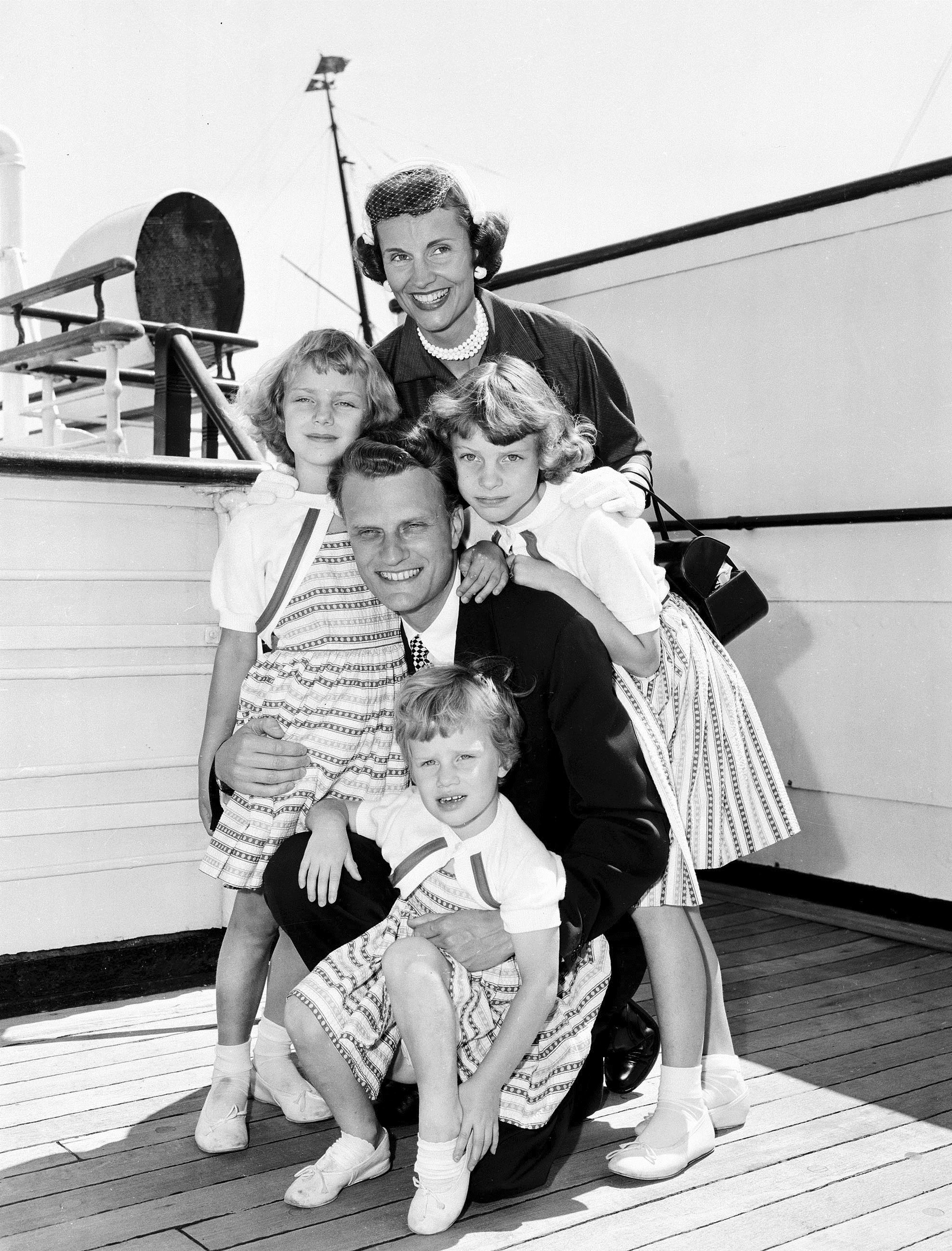 FILE - In this July 7, 1954 file photo, Evangelist Billy Graham poses with his his wife, Ruth, and their three daughters on the Queen Mary following his arrival in New York. Graham, who transformed American religious life through his preaching and activism, becoming a counselor to presidents and the most widely heard Christian evangelist in history, has died. Spokesman Mark DeMoss says Graham, who long suffered from cancer, pneumonia and other ailments, died at his home in North Carolina on Wednesday, Feb. 21, 2018. He was 99.(AP Photo)
