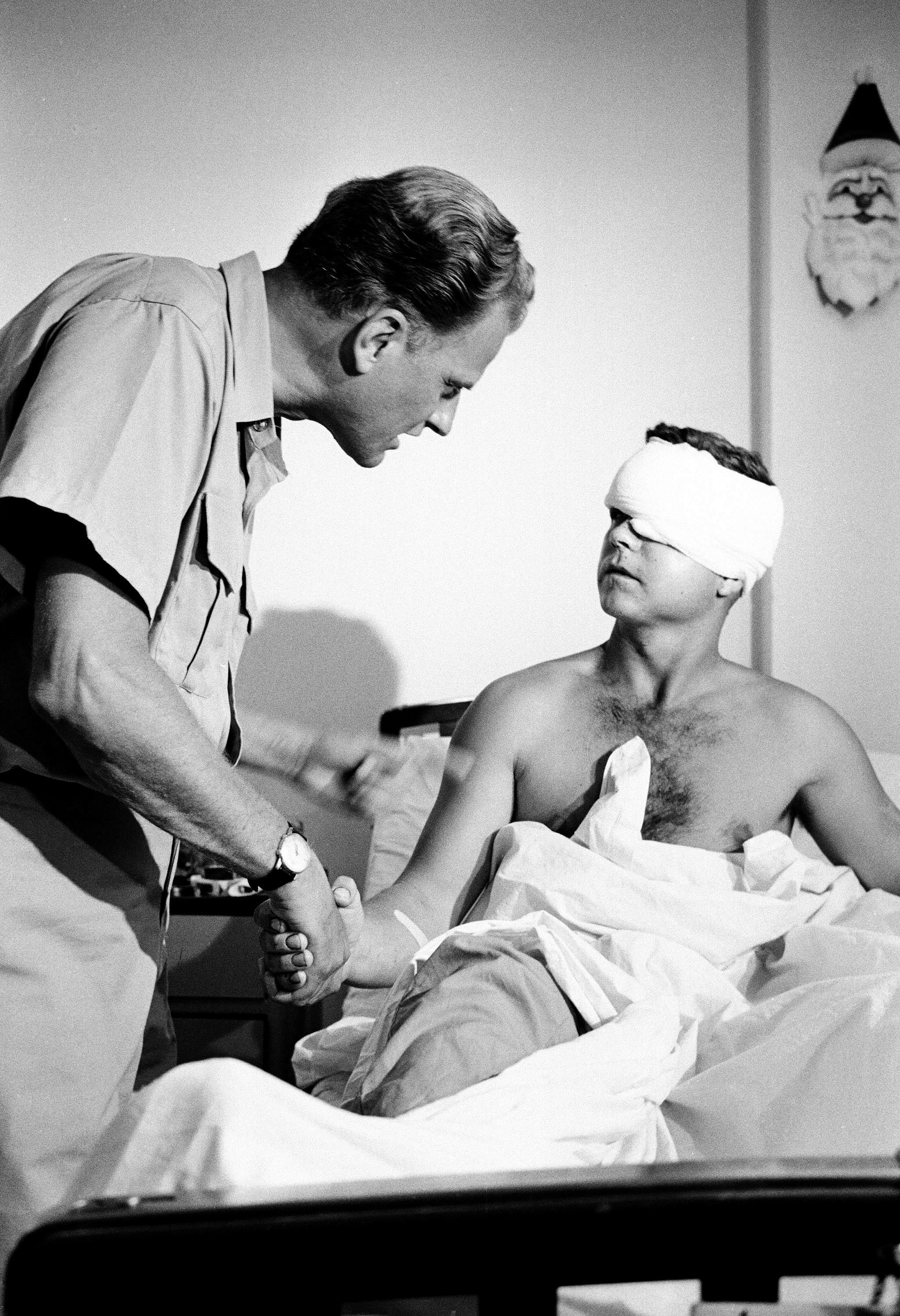 Army Pfc. Randolph Foster of Indiana is greeted by evangelist Billy Graham as he toured the U.S. 3rd Field Hospital in Saigon, Dec. 21, 1966. Graham had just addressed a gathering of some 2,000 U.S. troops on a soccer field at the Tan Son Nhut Airbase in Saigon. (AP Photo)
