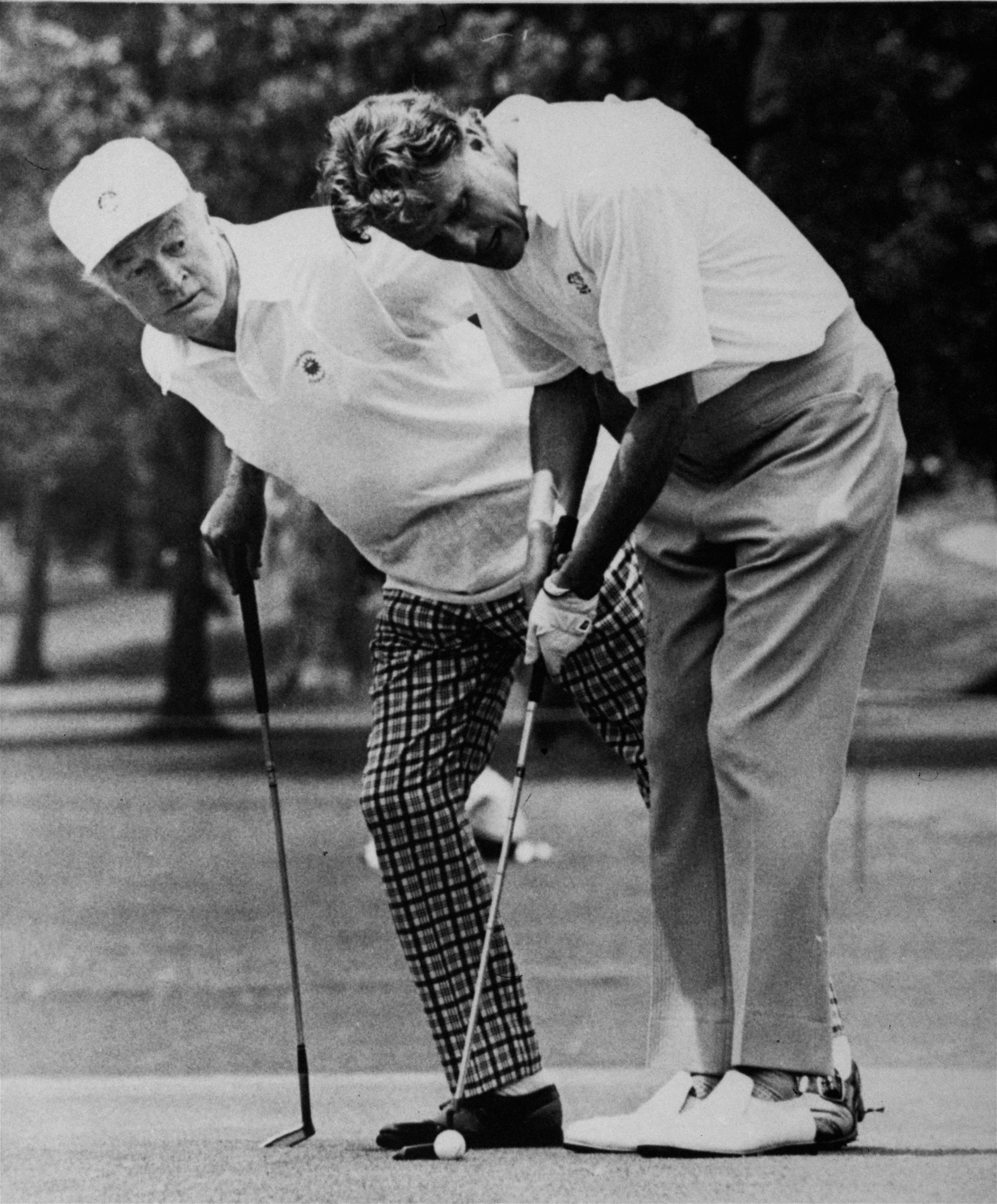 Comedian Bob Hope, left, takes a look as Evangelist Billy Graham lines up a putt during the Pro-Am play of the Byron Nelson Golf Classic in Dallas Wednesday, May 6, 1971. (AP Photo)