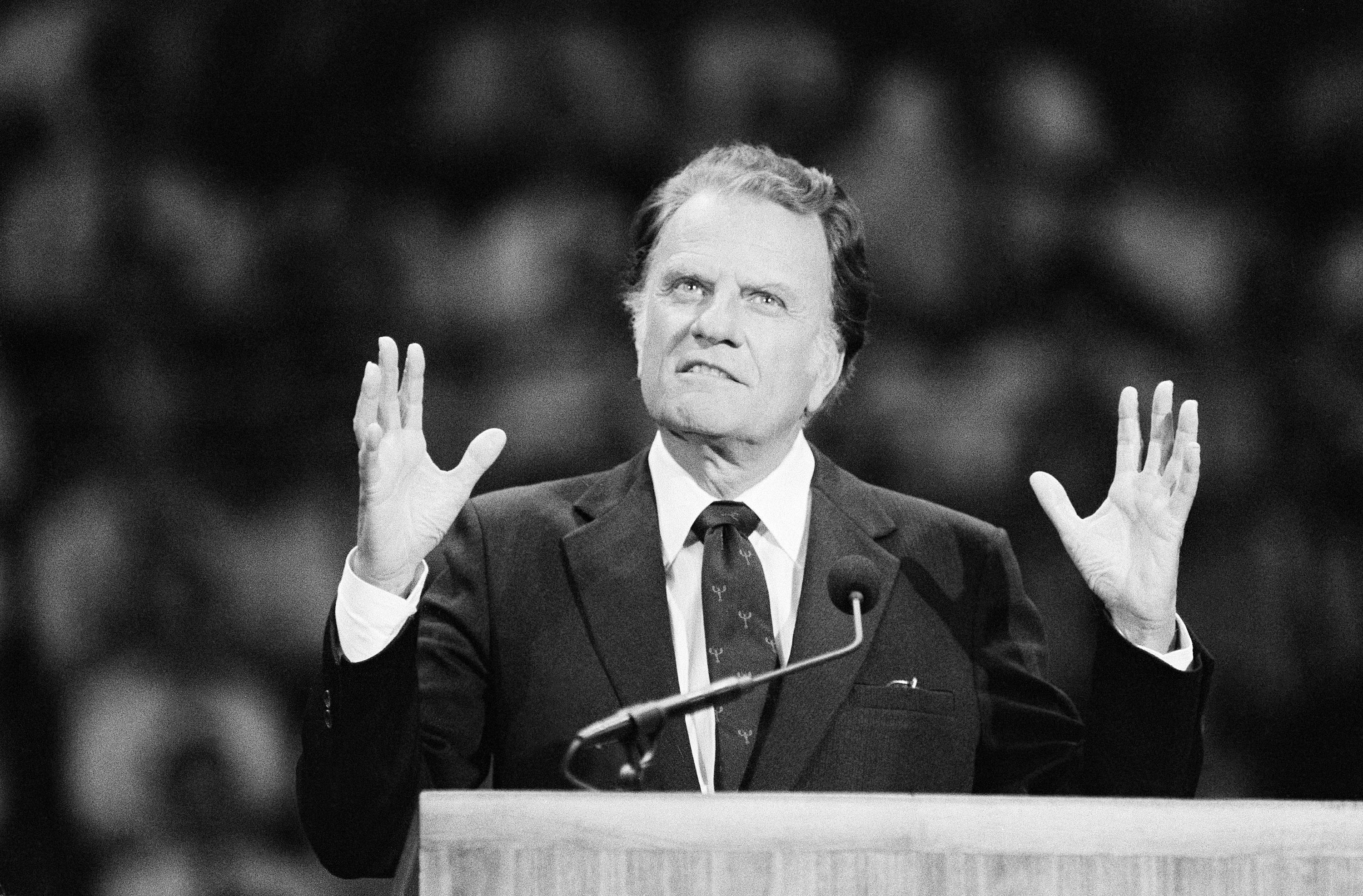 Rev. Billy Graham makes a point as he addresses a large crowd at the Hartford Civic Center in Connecticut, May 26, 1985. This was the last day of an eight-day crusade conducted by Graham in Hartford. (AP Photo/Bob Child)