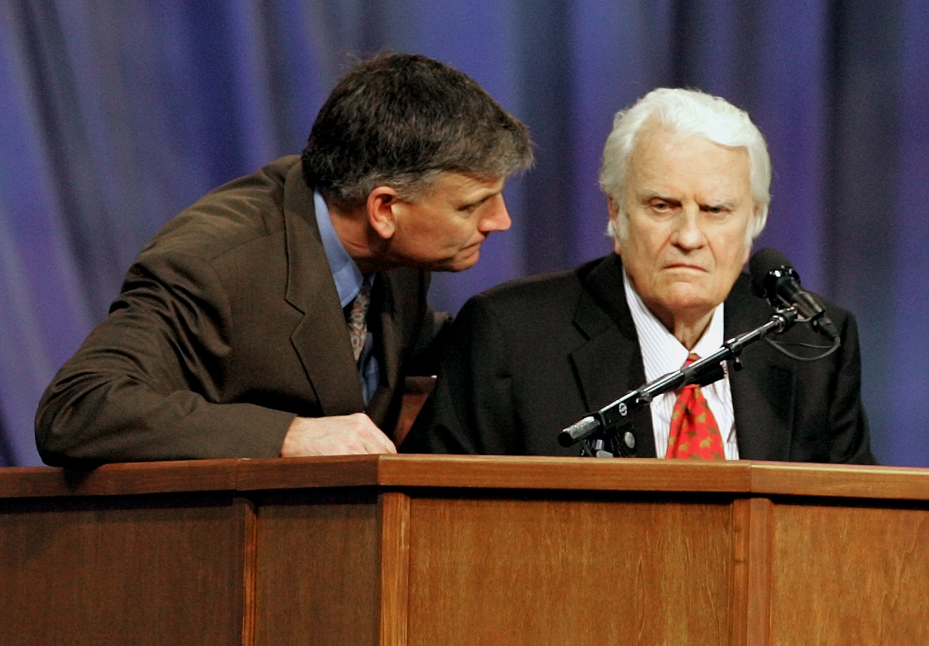Franklin Graham, left, talks to his father the Rev. Billy Graham during a service in New Orleans Sunday evening March 12, 2006. Graham is preaching for the first time since his service in New York in June. (AP Photo/Bill Haber)