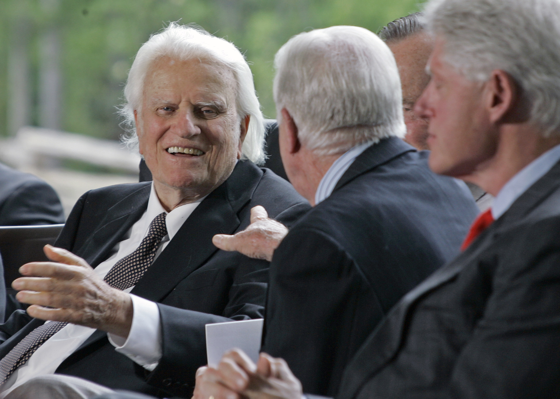 Billy Graham, left, reaches out to former President Jimmy Carter as Bill Clinton, far right looks on during the dedication for the Billy Graham Library in Charlotte, N.C., Thursday, May 31, 2007. (AP Photo/Chuck Burton)