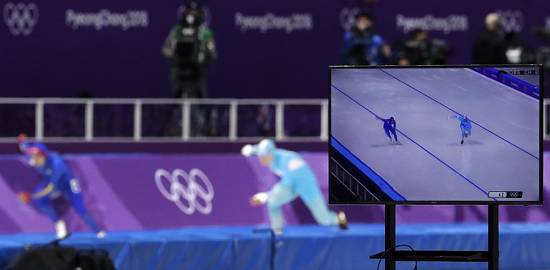 FILE- In this Feb. 19, 2018, photo, a TV screen shows Pedro Causil of Colombia, left on TV and rear left, and Stanislav Palkin of Kazakhstan, right on TV and rear center, competing during the men's 500 meters speedskating race at the Gangneung Oval at the 2018 Winter Olympics in Gangneung, South Korea. When it comes to the Olympics, too much choice can paralyze you with indecision. (AP Photo/Petr David Josek, File)