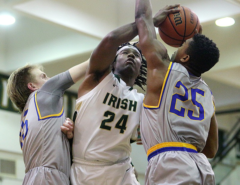 Notre Dame's Akil Sledge (24) must up a shot while being guarded by Goodpasture's Taylor Tinnin (15) and Amnon Turner (25) during the Notre Dame vs. Goodpasture boys' Division II state basketball tournament in Phifer Gymnasium at Notre Dame High School in Chattanooga, Tenn.