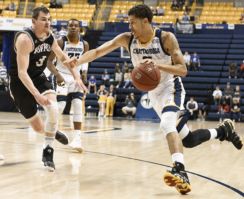 UTC's Nat Dixon (5) dribbles to the basket while Wofford's Fletcher Magree (3) defends in their game at McKenzie Arena last Saturday.