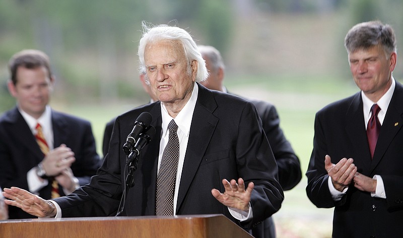 In this May 31, 2007 file photo, Billy Graham speaks as his son Franklin Graham, right, listens during a dedication ceremony for the Billy Graham Library in Charlotte, N.C.. Graham, who transformed American religious life through his preaching and activism, becoming a counselor to presidents and the most widely heard Christian evangelist in history, has died. Spokesman Mark DeMoss says Graham, who long suffered from cancer, pneumonia and other ailments, died at his home in North Carolina on Wednesday, Feb. 21, 2018. He was 99.(AP Photo/Gerry Broome)