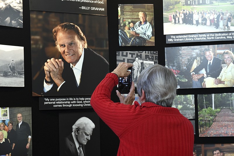Lyn Warwick of Black Mountain, N.C., photographs a memorial display of Rev. Billy Graham inside Chatlos Chapel at the Billy Graham Training Center at the Cove on Wednesday, February 21, 2018 in Asheville, NC. Warwick is friends with Gigi Graham, Billy Graham's daughter. (AP Photo/Kathy Kmonicek)
