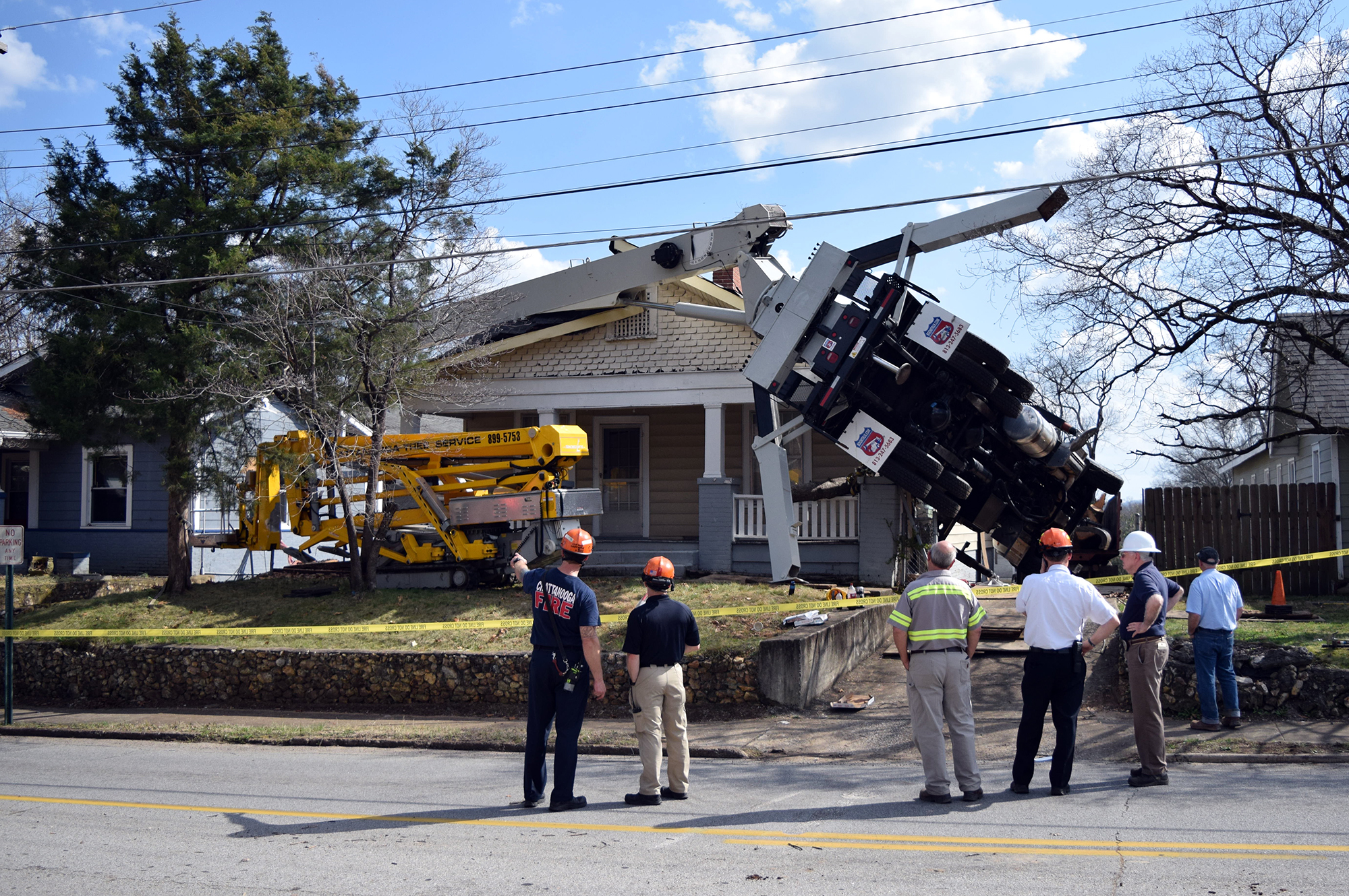 A truck with a crane doing tree work on the North Shore toppled over into two homes this afternoon.