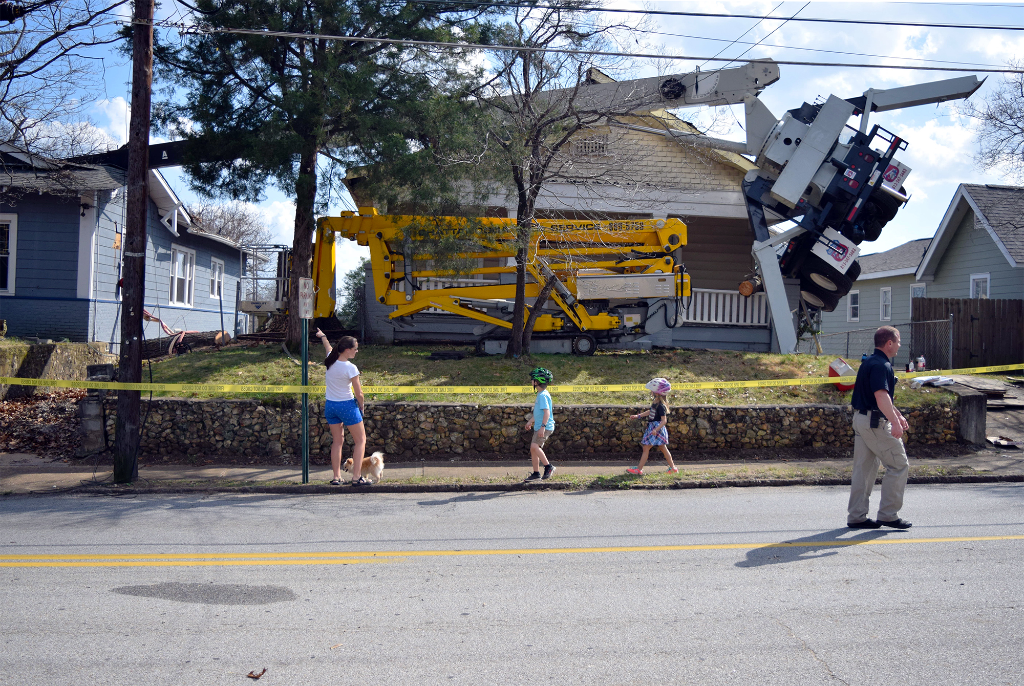 A truck with a crane doing tree work on the North Shore toppled over into two homes this afternoon.