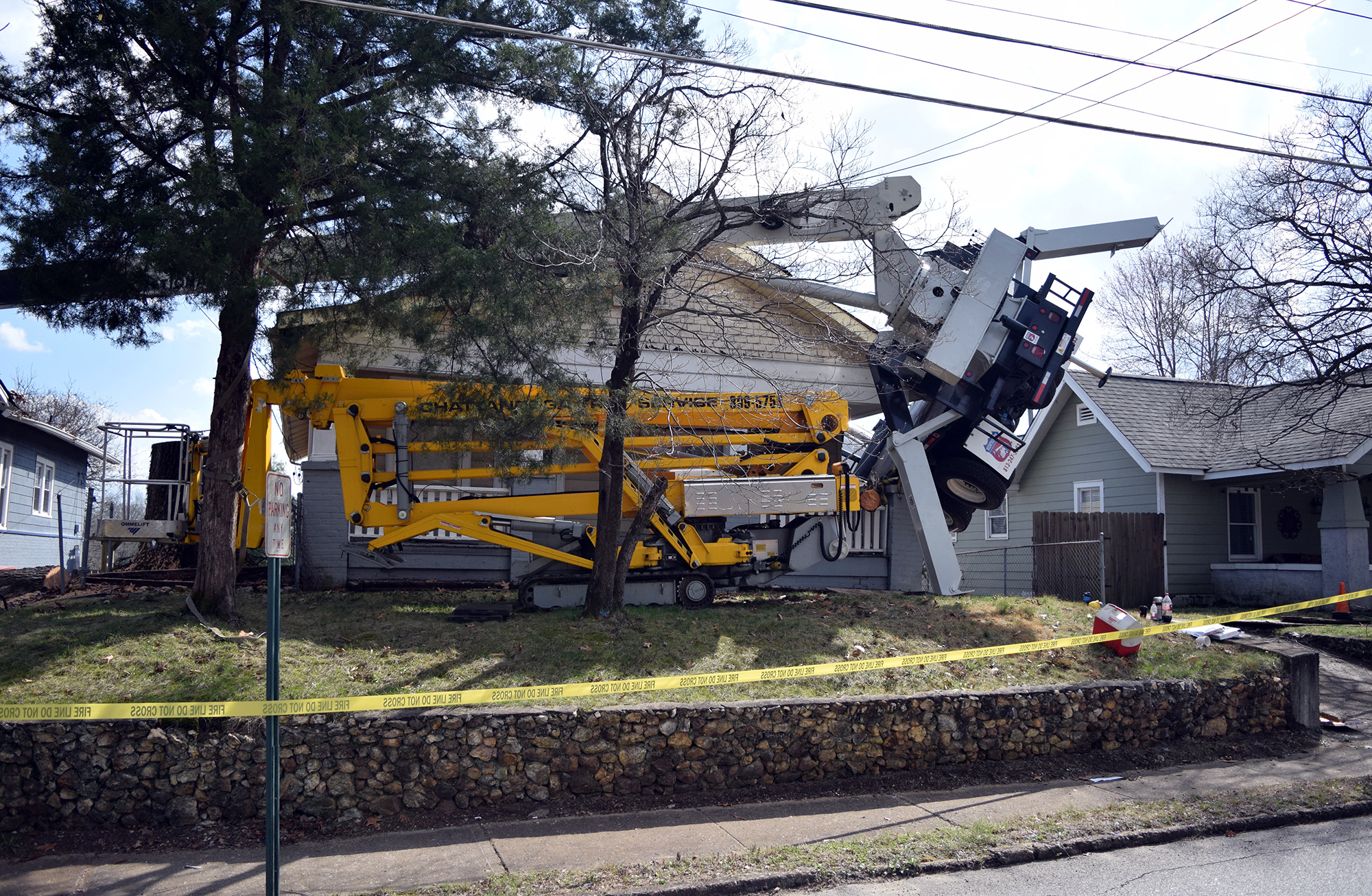 A truck with a crane doing tree work on the North Shore toppled over into two homes this afternoon.