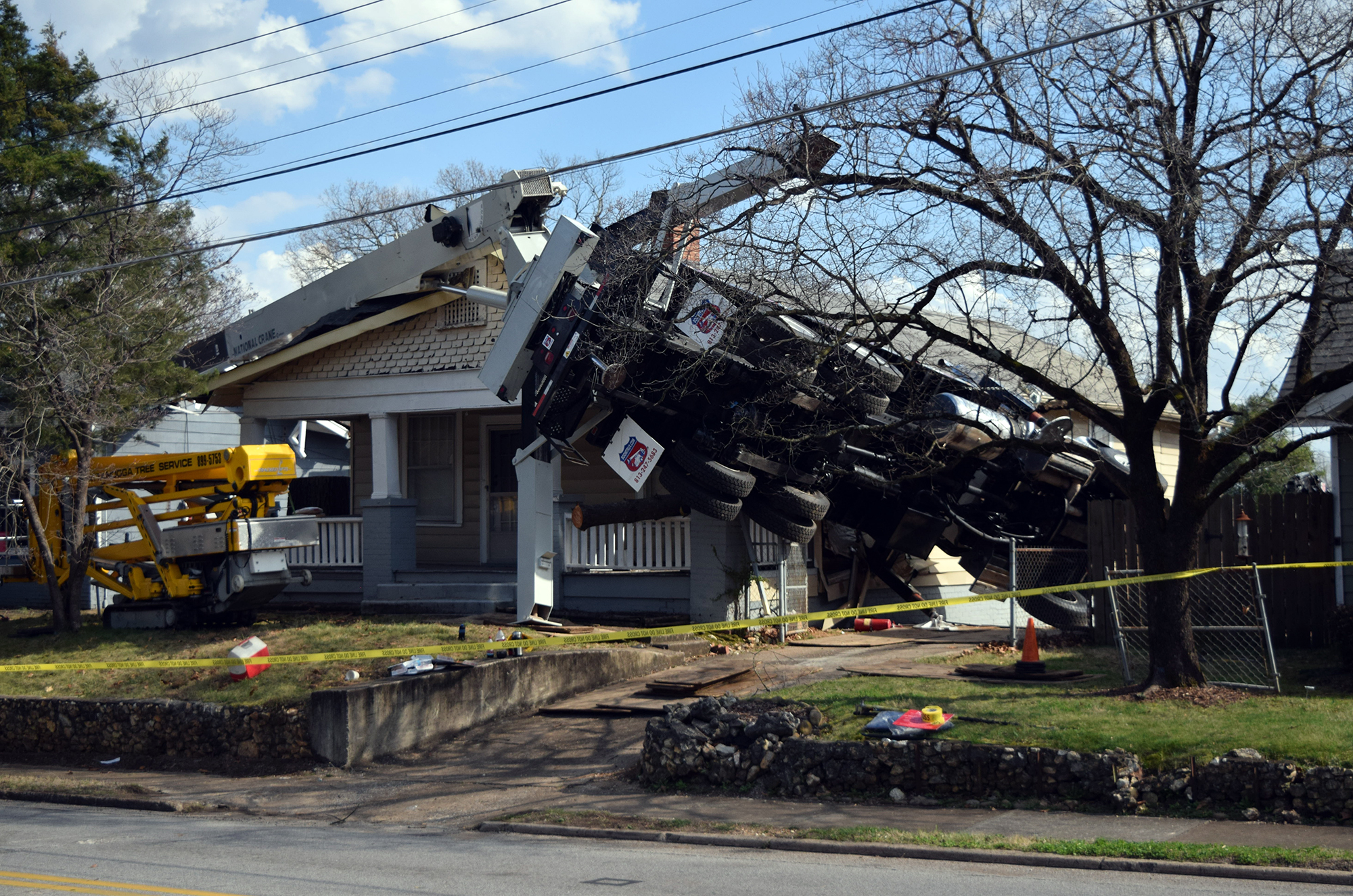 A truck with a crane doing tree work on the North Shore toppled over into two homes this afternoon.
