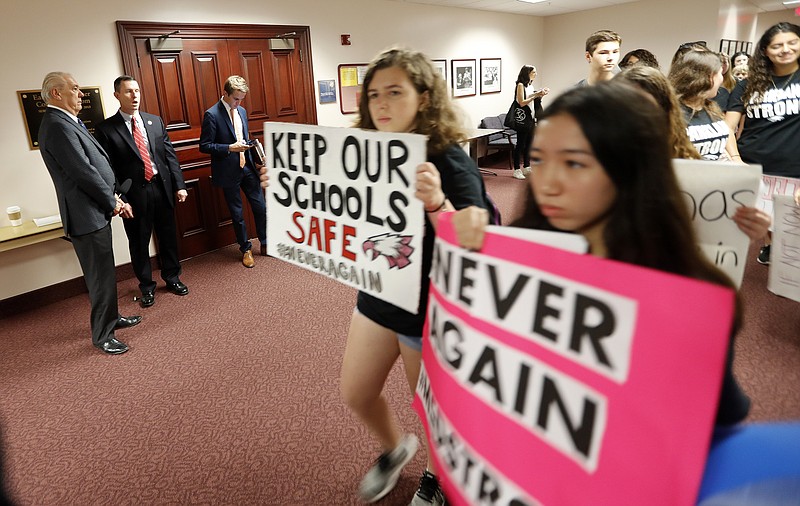 Student survivors from Marjory Stoneman Douglas High School, where 17 students and faculty were killed in a mass shooting last week, walk past the house legislative committee room in the state Capitol to talk to legislators about gun control. (AP Photo/Gerald Herbert)