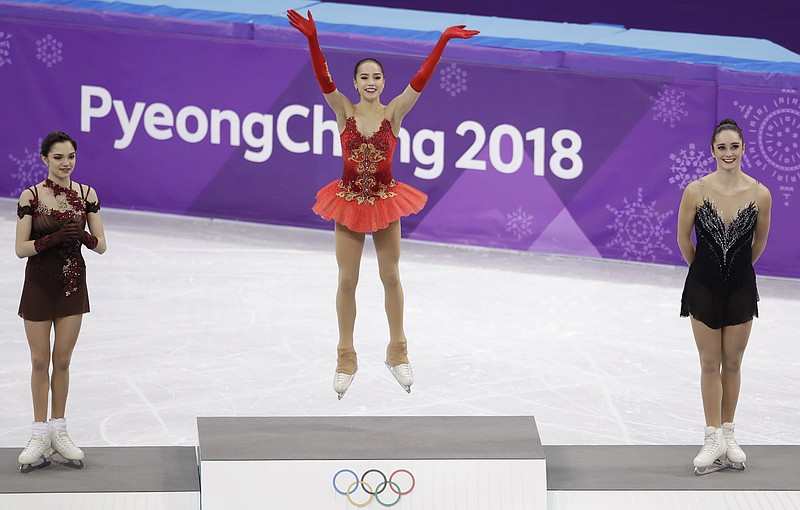 Gold medalist Alina Zagitova, centre, of the Olympic Athletes of Russia celebrates on the podium with compatriot and silver medalist Evgenia Medvedeva, left, and bronze medalist Kaetlyn Osmond of Canada at the women's free figure skating final in the Gangneung Ice Arena at the 2018 Winter Olympics in Gangneung, South Korea, Friday, Feb. 23, 2018. (AP Photo/Petr David Josek)