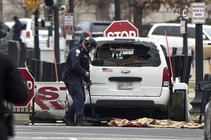 A Secret Service officer checks a white passenger vehicle that struck a security barrier that guards the southwest entrance to the White House grounds off of 17th Street n Washington, Friday, Feb. 23, 2018. (AP Photo/J. Scott Applewhite)