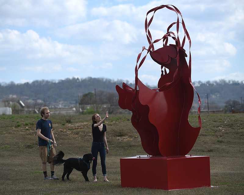 Eve Hermann and Nick York walk Caboose Thursday, Feb. 23, 2017 in Sculpture Fields at Montague Park