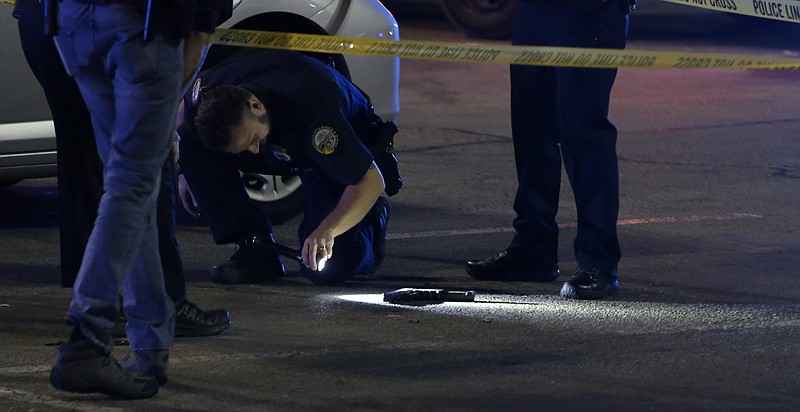 Law enforcement inspect a gun outside of the entrance near Rodizio Grill and Sears at the Hamilton Place mall on Saturday, Feb. 24, 2018 in Chattanooga, Tenn.