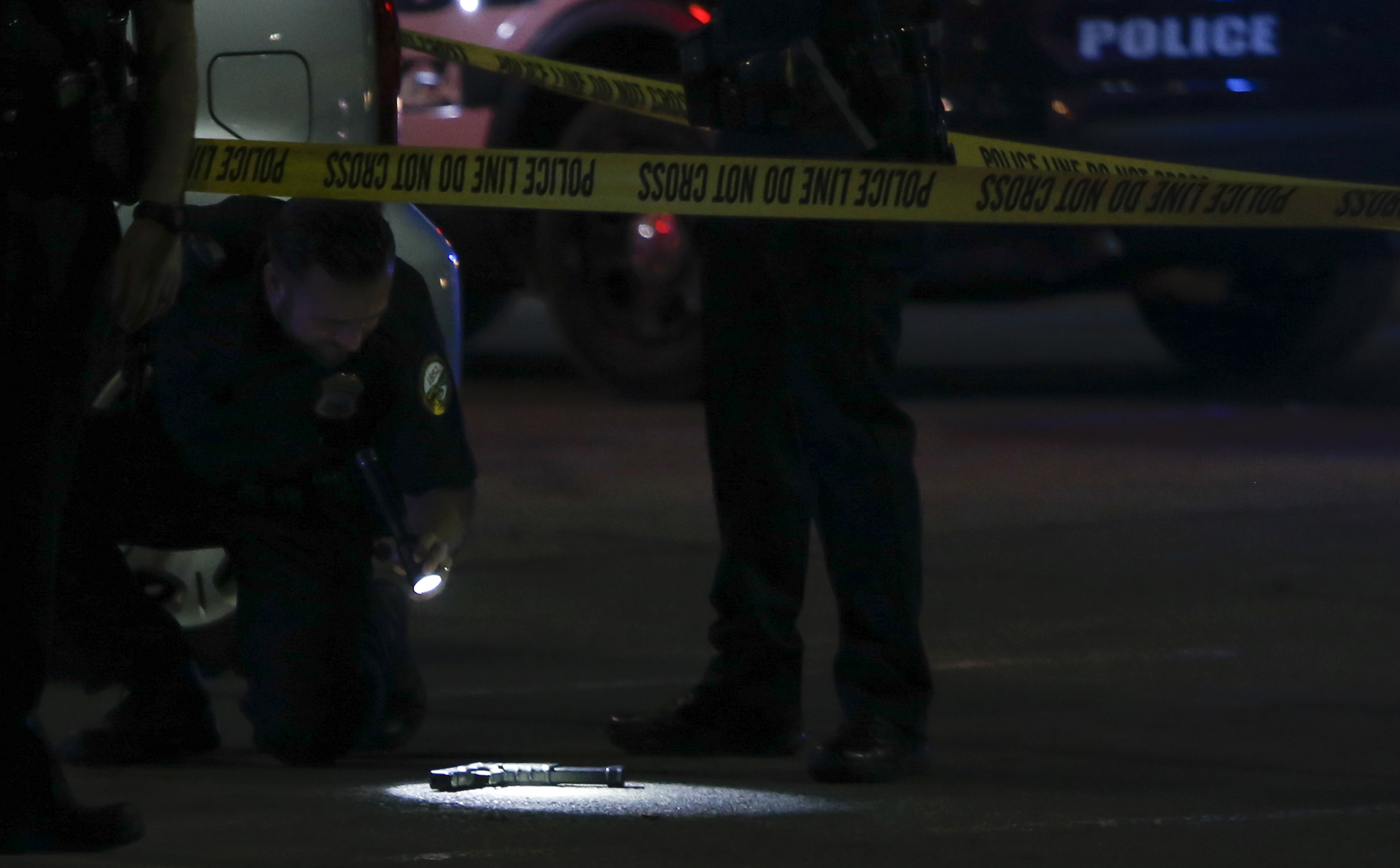 Law enforcement inspect a gun outside of the entrance near Rodizio Grill and Sears at the Hamilton Place mall on Saturday, Feb. 24, 2018 in Chattanooga, Tenn.