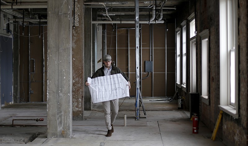 Senior Manager Doug Chapin walkers through the site of the former English Rose tea room carrying building plans on Monday, Feb. 19, 2018 in Chattanooga, Tenn. Clumpies Ice Cream is moving into the location.