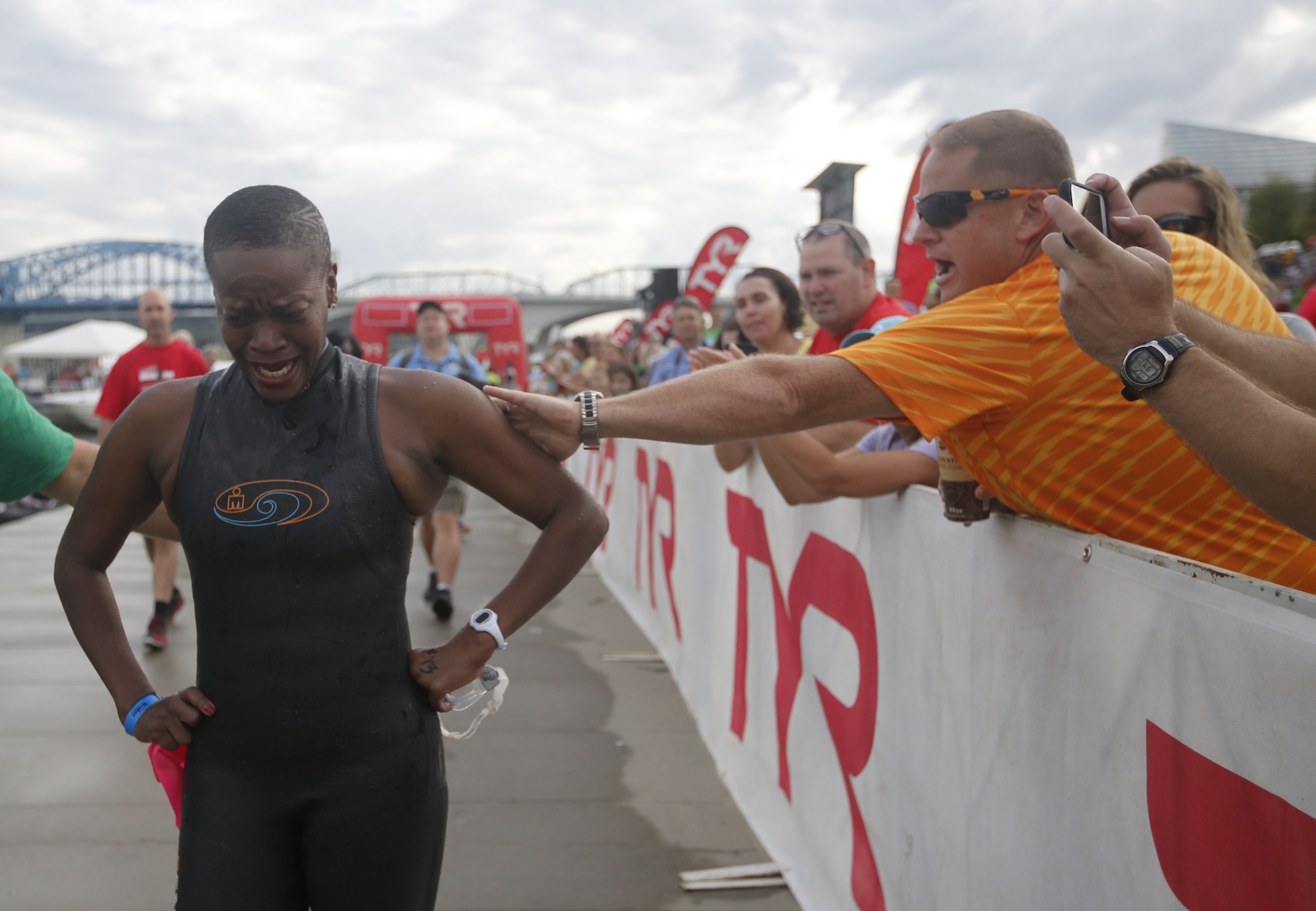 Fans cheer for local athlete Alexis Willis at Ross's Landing as she reacts to being the final finisher in the swim portion of the the Ironman Triathlon on Sunday, Sept. 28, 2014, in Chattanooga, Tenn. This was the first Ironman held in Chattanooga.