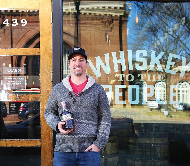 Chattanooga Whiskey Co. co-founder and CEO Tim Piersant holds a bottle of Chattanooga Whiskey outside the company's Tennessee Stillhouse on Market Street.