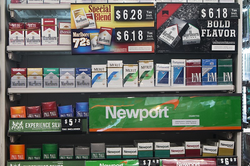 FILE - In this Thursday, May 18, 2017 file photo, packs of cigarettes are offered for sale at a convenience store in Helena, Mont. Tobacco companies have made claims about “safer” cigarettes since the 1950s, all later proven false. In some cases the introduction of these products, such as filtered and “low tar” cigarettes, propped up cigarette sales and kept millions of Americans smoking. Although the adult smoking rate has fallen to an all-time low of 15 percent in 2017, smoking remains the nation's leading preventable cause of death and illness, responsible for about one in five U.S. deaths. (AP Photo/Bobby Caina Calvan)