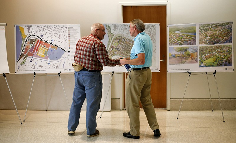 Wally Reece, left, and Larry Aulich shake hands as they look at plans for the South Broad District revitalization before a community meeting at the Development Resource Center on Monday, Feb. 26, 2018 in Chattanooga, Tenn.