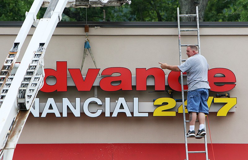 John Polly, a sign technician with Adams Signs out of Nashville, Tenn., works on the Advance Financial 24/7 sign Wednesday, Aug. 2, 2017, in Chattanooga, Tenn. Employees from Adams Signs were going to most Advance Financial 24/7 locations to ensure all signs were installed correctly and were still secure. 