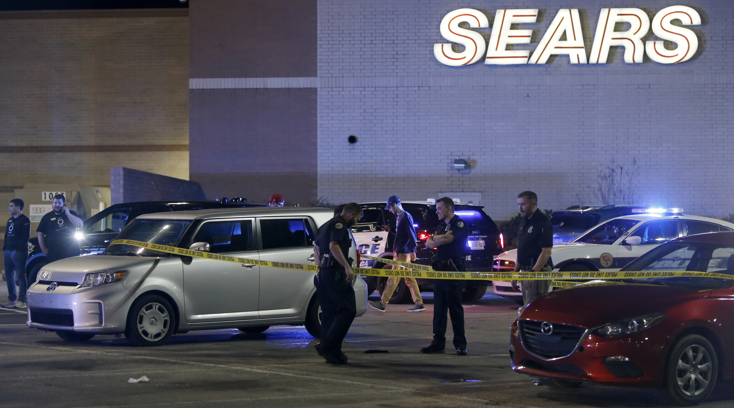 Law enforcement inspect a gun outside of the entrance near Rodizio Grill and Sears at the Hamilton Place mall on Saturday, Feb. 24, 2018 in Chattanooga, Tenn.