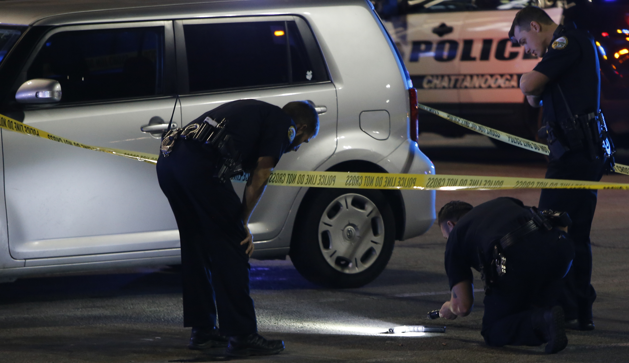 Law enforcement inspect a gun outside of the entrance near Rodizio Grill and Sears at the Hamilton Place mall on Saturday, Feb. 24, 2018 in Chattanooga, Tenn.