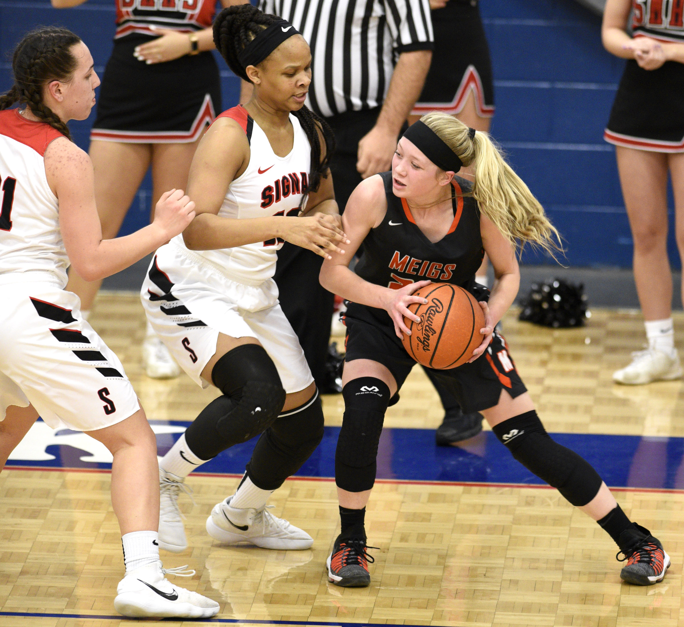 Meigs's Kassidy Kenny (23) tries to get past the defense of Signal's Jaylah Hardy (12) and Jolie McGann (21). The Meigs County Tigers played the Signal Mountain Eagles in the semi-final game of the girls's Region 3-AA TSSAA Tournament held at Red Bank High School on February 26, 2018.