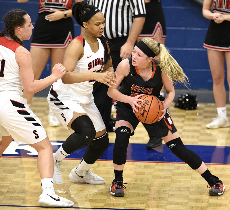 Meigs's Kassidy Kenny (23) tries to get past the defense of Signal's Jaylah Hardy (12) and Jolie McGann (21).  The Meigs County Tigers played the Signal Mountain Eagles in the semi-final game of the girls's Region 3-AA TSSAA Tournament held at Red Bank High School on February 26, 2018. 