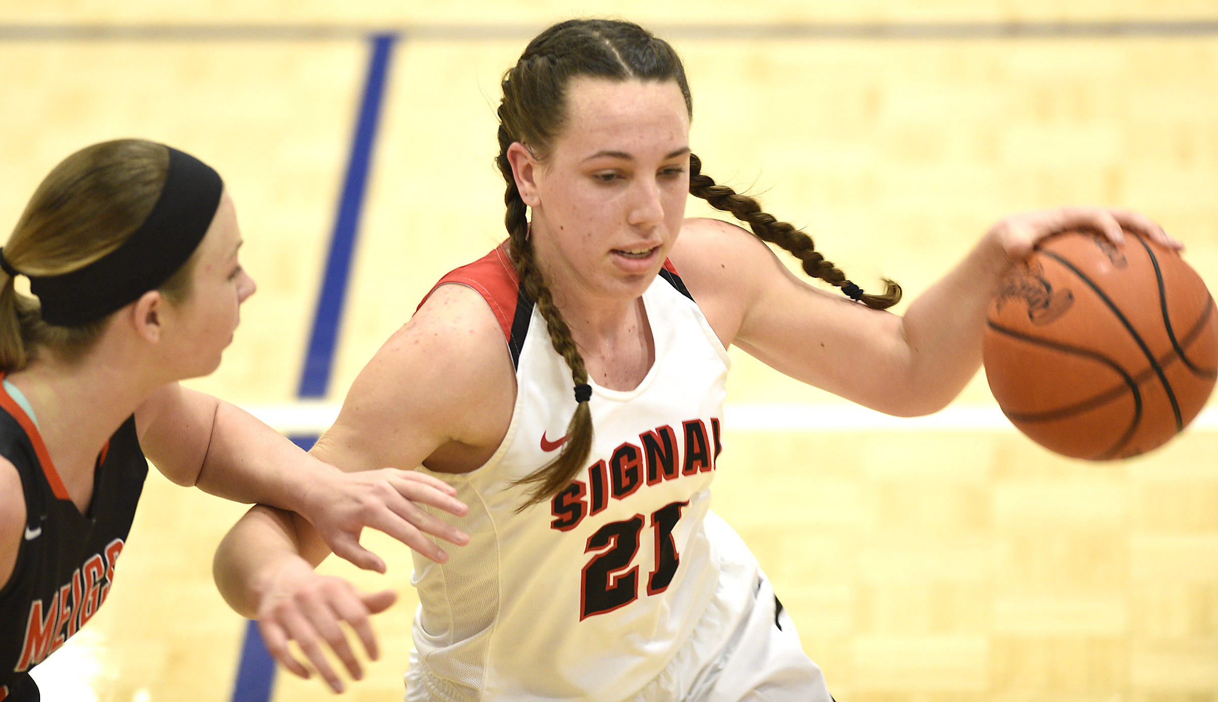 Signal's Jolie McGann (21) brings the ball up court, while Meigs's Krista Crager (2) defends. The Meigs County Tigers played the Signal Mountain Eagles in the semi-final game of the girls's Region 3-AA TSSAA Tournament held at Red Bank High School on February 26, 2018.
