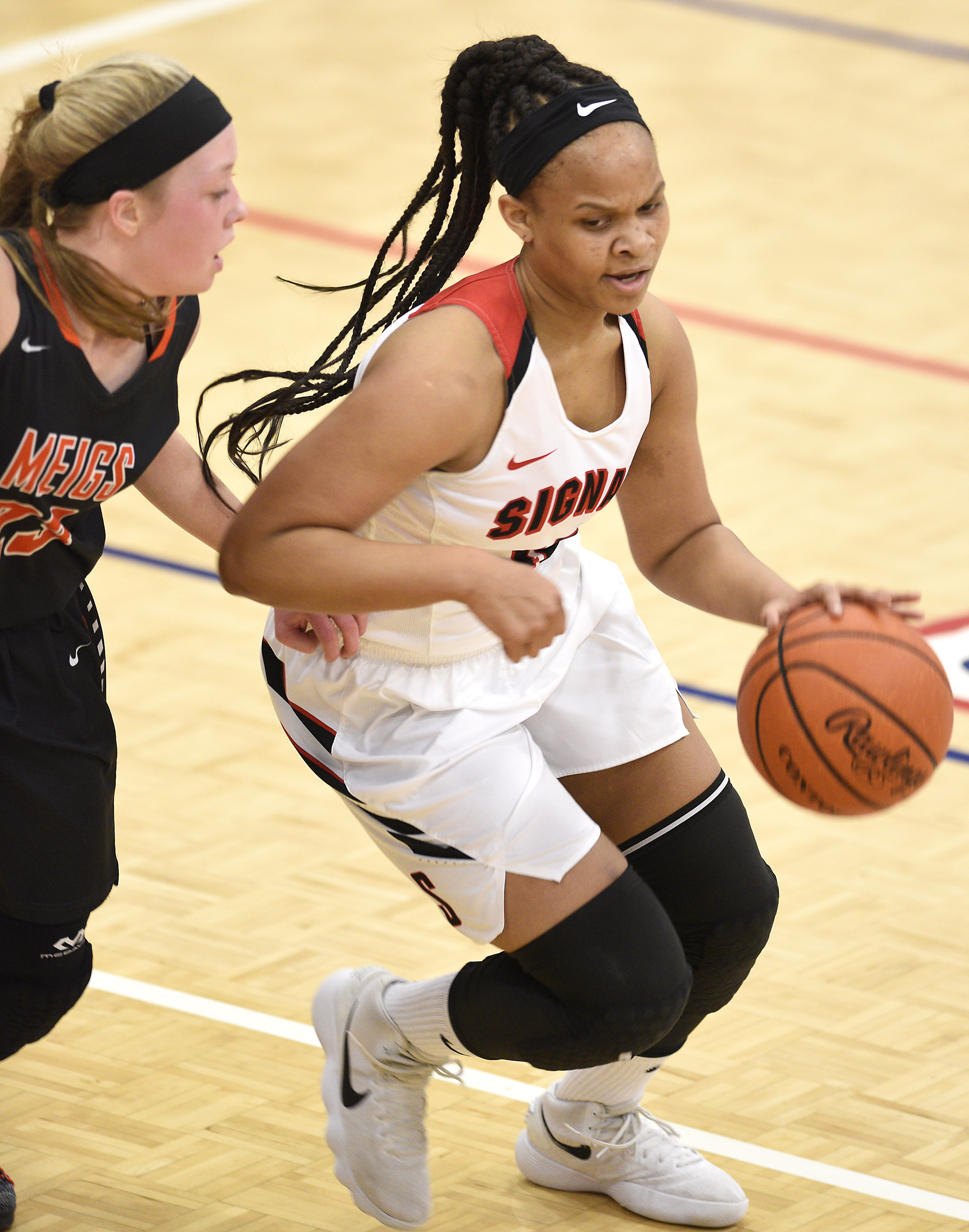 Signal's Jaylah Hardy (12) dribbles past Meigs's Kassidy Kenny (23). The Meigs County Tigers played the Signal Mountain Eagles in the semi-final game of the girls's Region 3-AA TSSAA Tournament held at Red Bank High School on February 26, 2018.