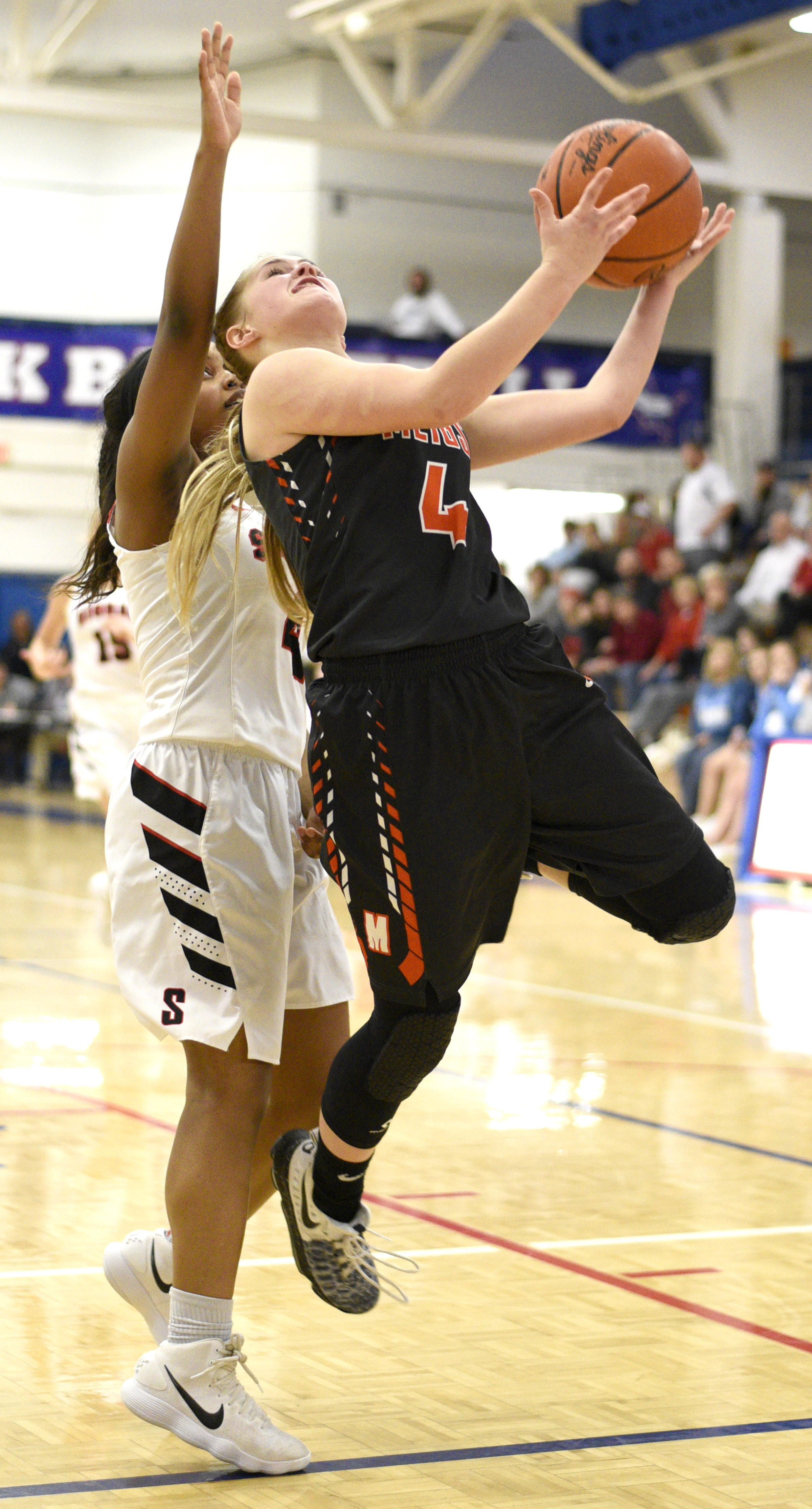 Meigs's Jacelyn Stone (4) drives in for a layup. Defending is Signal's Kendall Davis (4). The Meigs County Tigers played the Signal Mountain Eagles in the semi-final game of the girls's Region 3-AA TSSAA Tournament held at Red Bank High School on February 26, 2018.