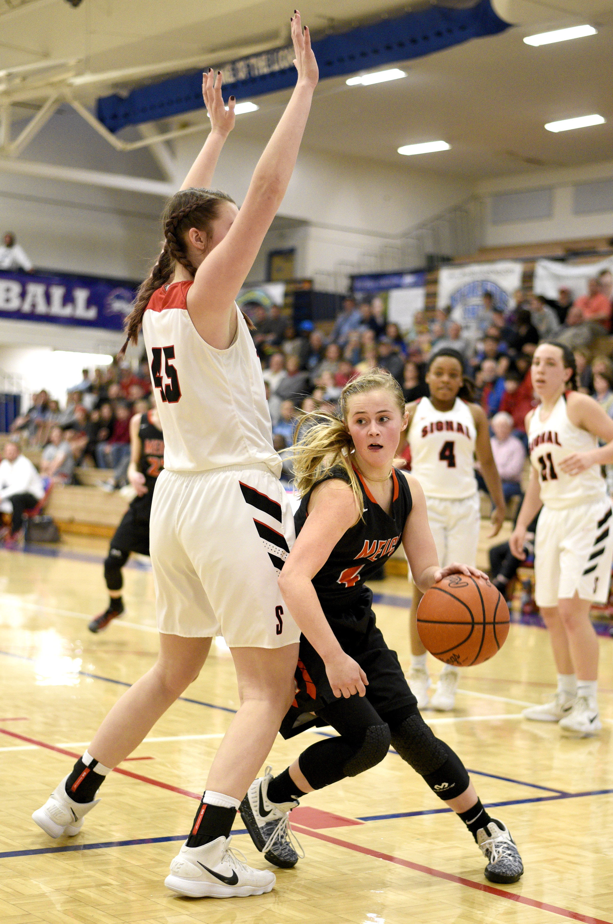 Meigs's Jacelyn Stone (4) dribbles around Signal's Olivia Koontz (45). The Meigs County Tigers played the Signal Mountain Eagles in the semi-final game of the girls's Region 3-AA TSSAA Tournament held at Red Bank High School on February 26, 2018.