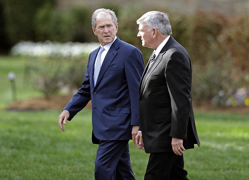 Former President George W. Bush, left, talks with Franklin Graham as he arrives to pay respects to Billy Graham during a public viewing at the Billy Graham Library in Charlotte, N.C., Monday, Feb. 26, 2018. (AP Photo/Chuck Burton)